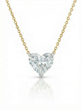 Heart-shaped diamond pendant on a gold chain against a white background