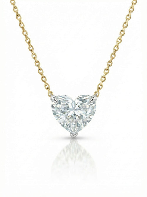 Heart-shaped diamond pendant on a gold chain against a white background