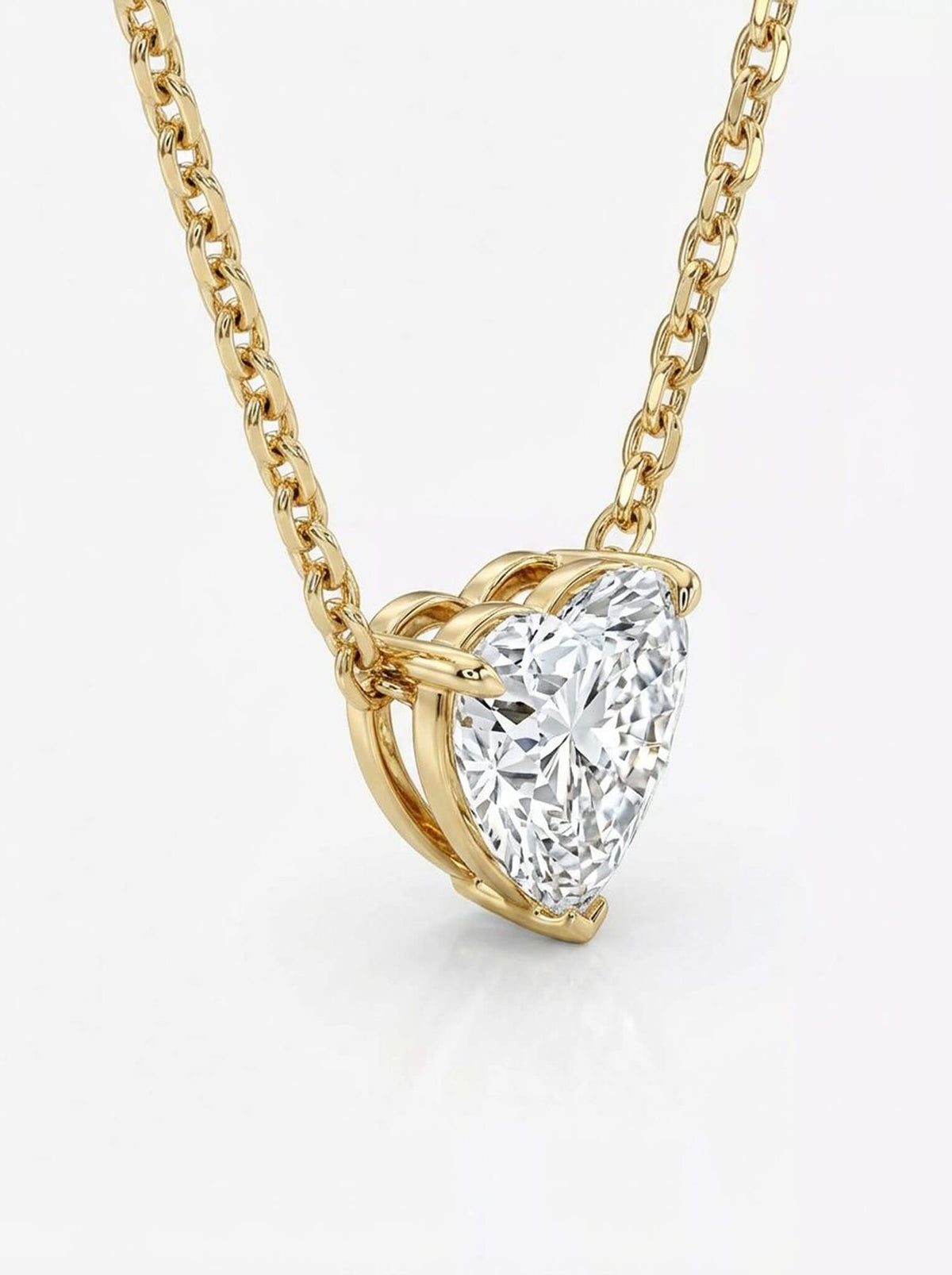 Gold necklace with a heart-shaped diamond pendant on a white background